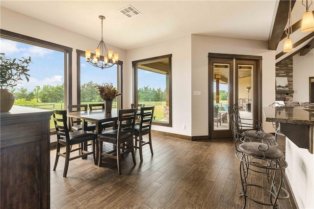 dining room featuring visible vents, a chandelier, dark wood-style floors, and baseboards