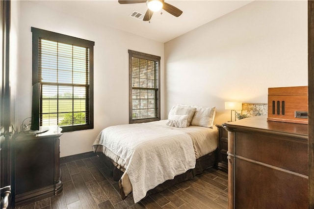 bedroom with visible vents, baseboards, ceiling fan, and dark wood-type flooring
