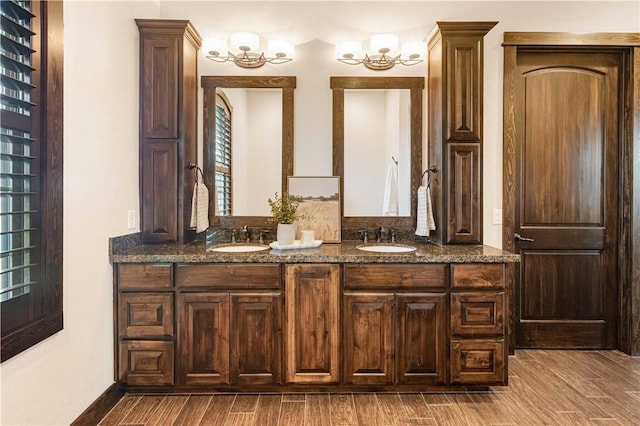 full bath with an inviting chandelier, a sink, and wood finished floors