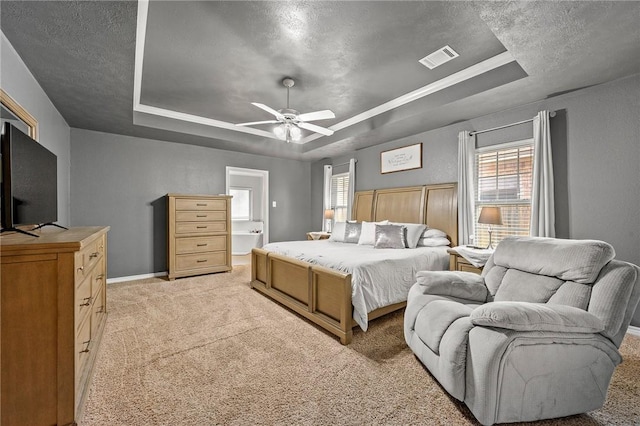 912 Emerald Dove Ave, College Station, TX 77845 - bedroom with a tray ceiling, multiple windows, light carpet, and a textured ceiling