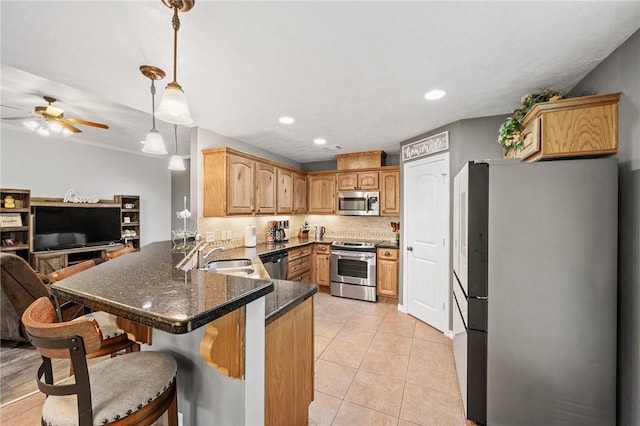 912 Emerald Dove Ave, College Station, TX 77845 - kitchen featuring appliances with stainless steel finishes, a sink, a peninsula, a ceiling fan, and tasteful backsplash