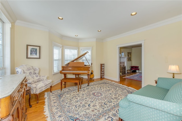 living room with light wood-type flooring, crown molding, and baseboards