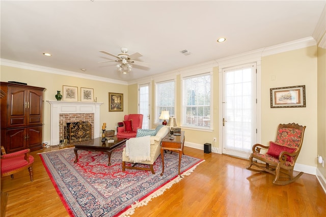 living area featuring light wood-style flooring, visible vents, and ornamental molding