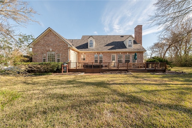 rear view of house featuring brick siding, a lawn, and a deck