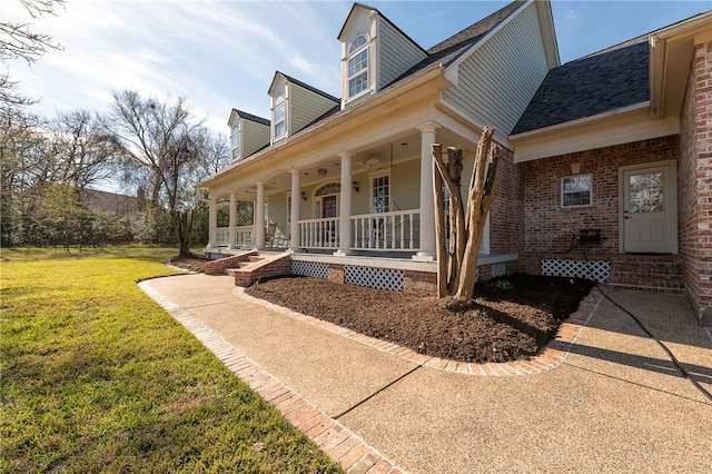 exterior space featuring a front yard, covered porch, and brick siding