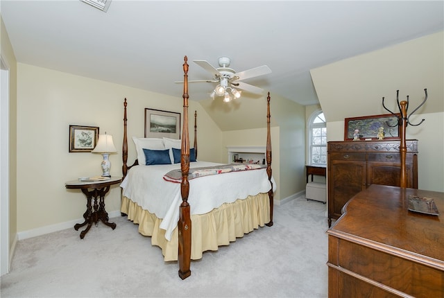 bedroom with lofted ceiling, light colored carpet, ceiling fan, and baseboards