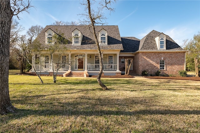 cape cod home with a porch, a front yard, brick siding, and roof with shingles