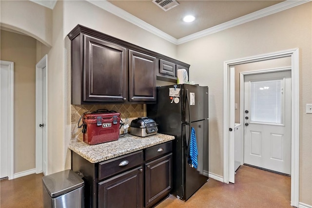 kitchen featuring black refrigerator, ornamental molding, backsplash, and dark brown cabinets