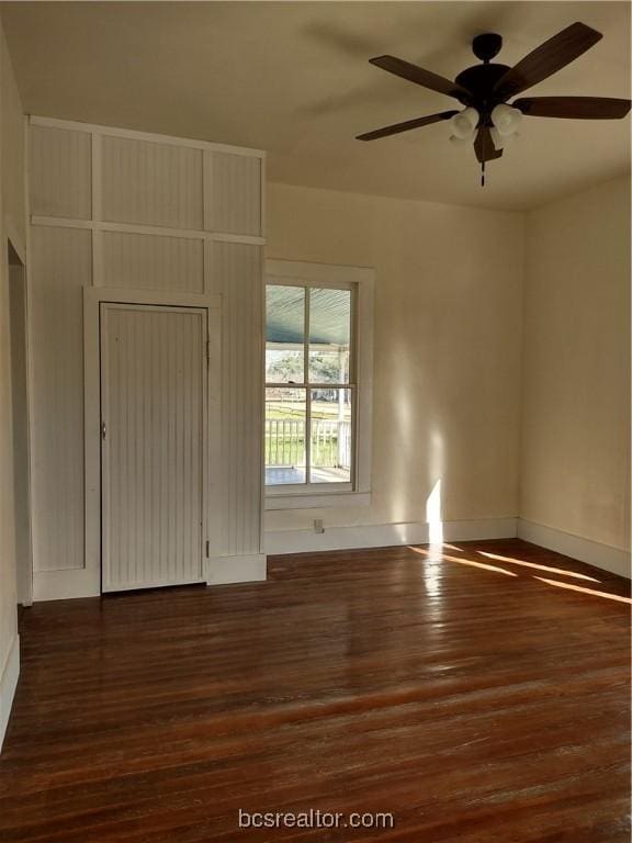 empty room featuring ceiling fan and dark wood-type flooring