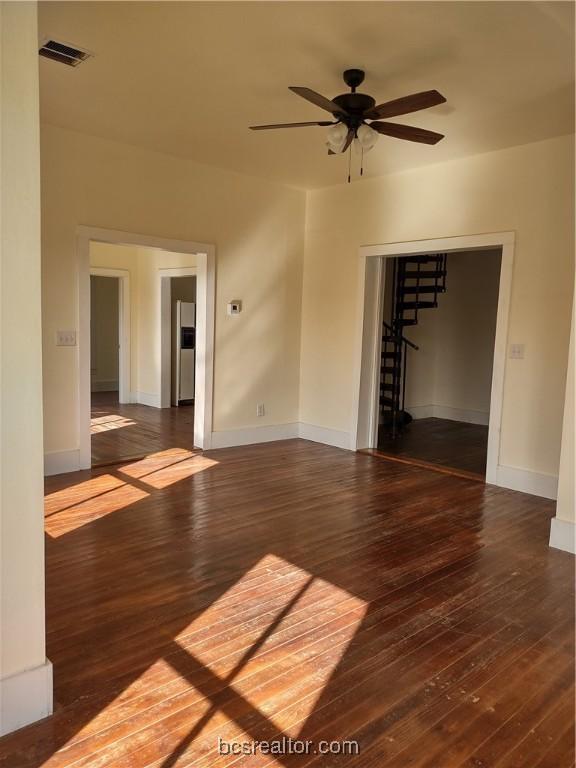 spare room featuring dark hardwood / wood-style flooring and ceiling fan