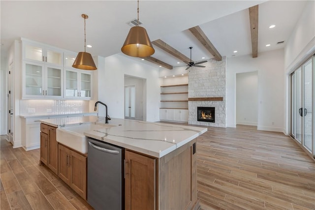 kitchen with sink, white cabinetry, hanging light fixtures, dishwasher, and a kitchen island with sink