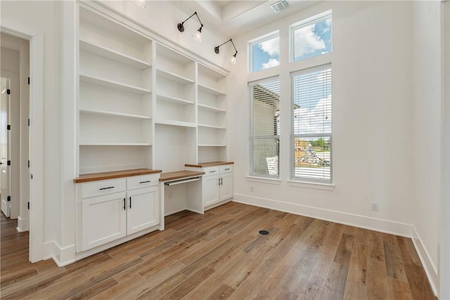 interior space featuring plenty of natural light, built in desk, and light hardwood / wood-style floors