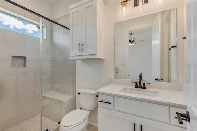 bathroom featuring walk in shower, ceiling fan, vanity, and toilet