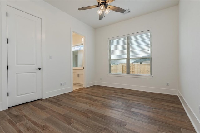 unfurnished bedroom with ceiling fan, dark hardwood / wood-style flooring, and ensuite bath