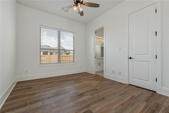 unfurnished bedroom with dark hardwood / wood-style flooring, connected bathroom, and ceiling fan