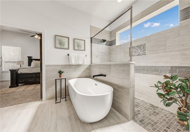 bathroom featuring separate shower and tub, tile walls, and ceiling fan