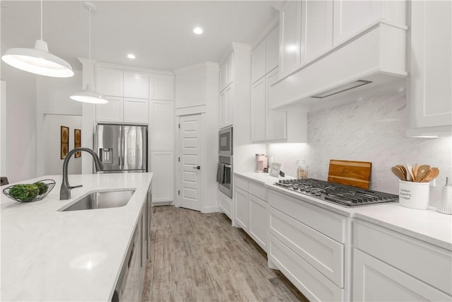 kitchen with sink, hanging light fixtures, stainless steel appliances, decorative backsplash, and white cabinets