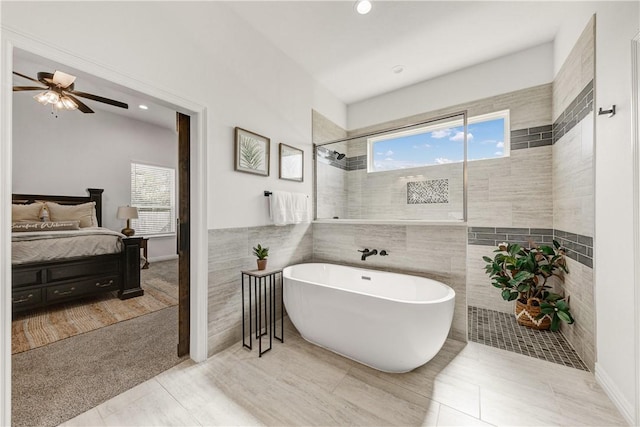 bathroom featuring separate shower and tub, tile patterned floors, ceiling fan, and tile walls