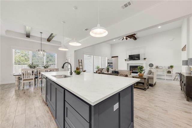 kitchen featuring pendant lighting, plenty of natural light, gray cabinets, and sink