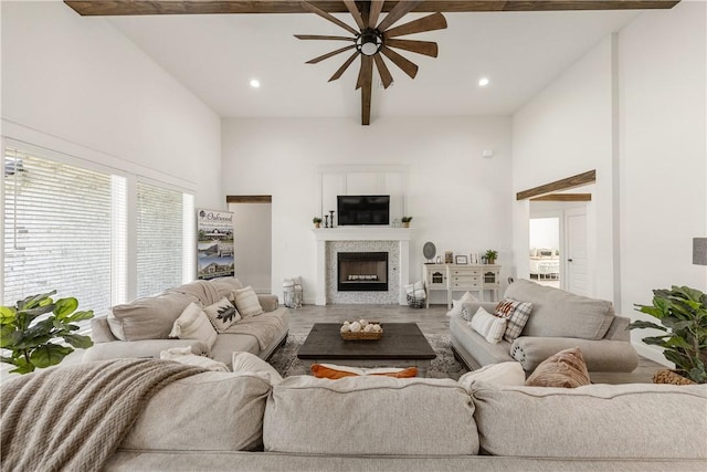 living room featuring beam ceiling, hardwood / wood-style flooring, high vaulted ceiling, and ceiling fan