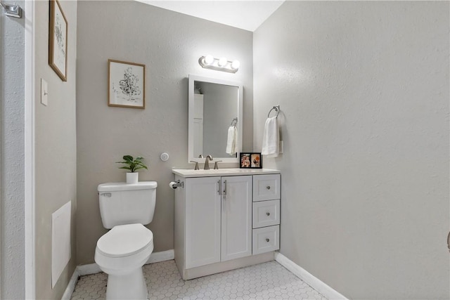 bathroom featuring baseboards, vanity, toilet, and tile patterned floors