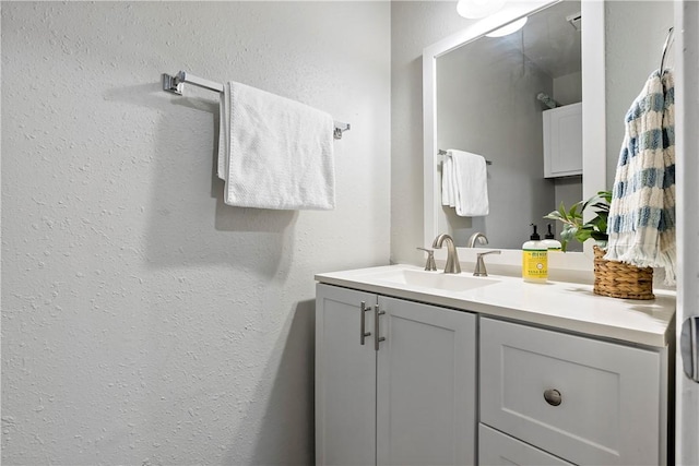 bathroom featuring a textured wall and vanity