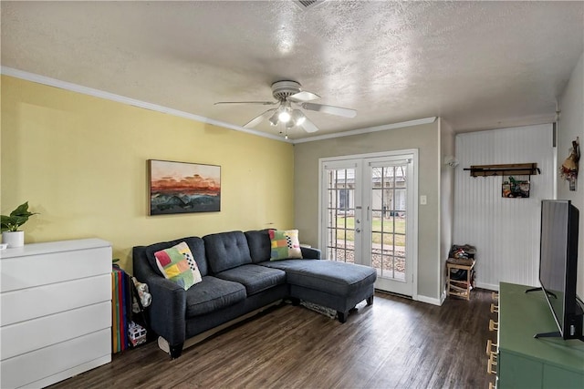 living area with french doors, dark wood-type flooring, ornamental molding, a textured ceiling, and baseboards