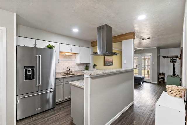 kitchen featuring a sink, dark wood-style flooring, high end refrigerator, and island exhaust hood