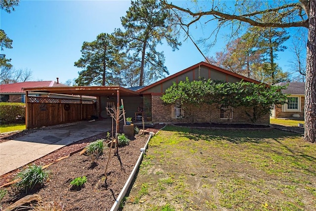 view of front facade with an attached carport, brick siding, driveway, and a front lawn