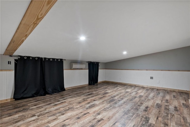 bonus room with hardwood / wood-style flooring, a wall mounted air conditioner, and vaulted ceiling