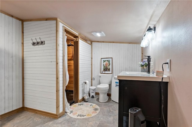 bathroom with vanity, toilet, walk in shower, and wooden walls