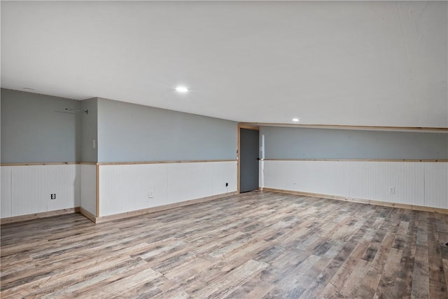 spare room featuring light hardwood / wood-style flooring and wood walls