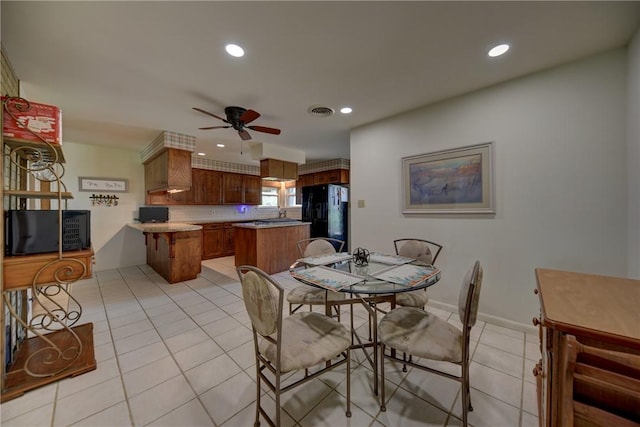 tiled dining space with ceiling fan