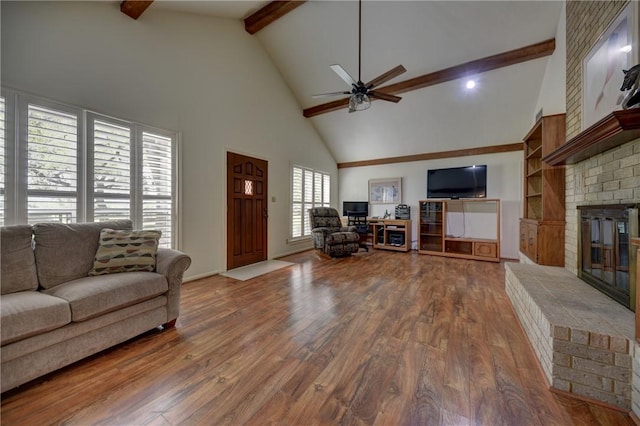 living room with a fireplace, beam ceiling, high vaulted ceiling, and a wealth of natural light