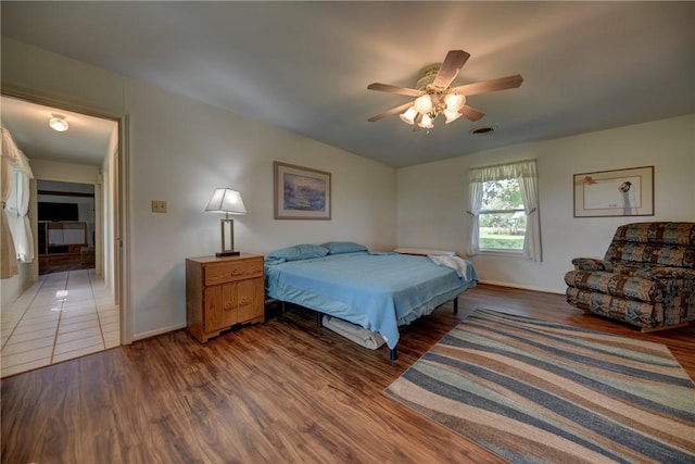 bedroom with dark hardwood / wood-style floors and ceiling fan