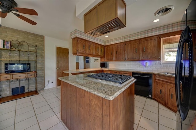 kitchen featuring backsplash, light tile patterned floors, light stone counters, a center island, and black appliances