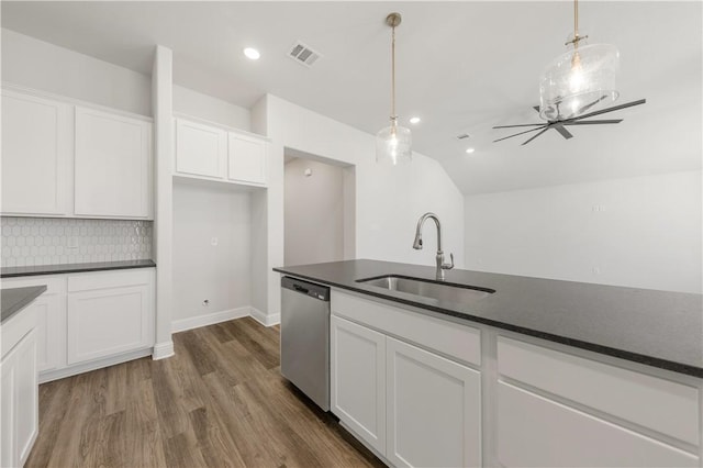 kitchen with a sink, visible vents, stainless steel dishwasher, and dark countertops