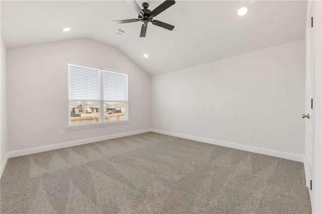 carpeted spare room featuring visible vents, lofted ceiling, baseboards, and a ceiling fan