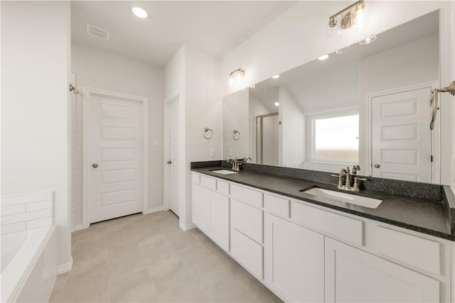 bathroom featuring a sink, a garden tub, double vanity, and a shower stall