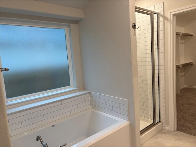 bathroom featuring tile patterned flooring and separate shower and tub