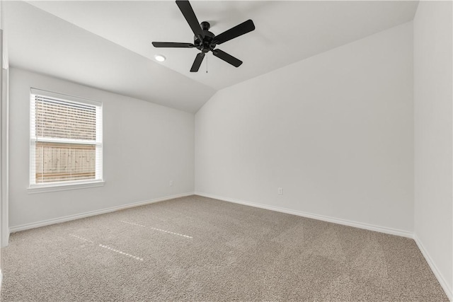 carpeted spare room with baseboards, lofted ceiling, and a ceiling fan