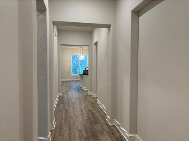 hallway featuring a chandelier and dark hardwood / wood-style flooring