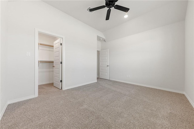 unfurnished bedroom with carpet flooring, visible vents, a walk in closet, and baseboards