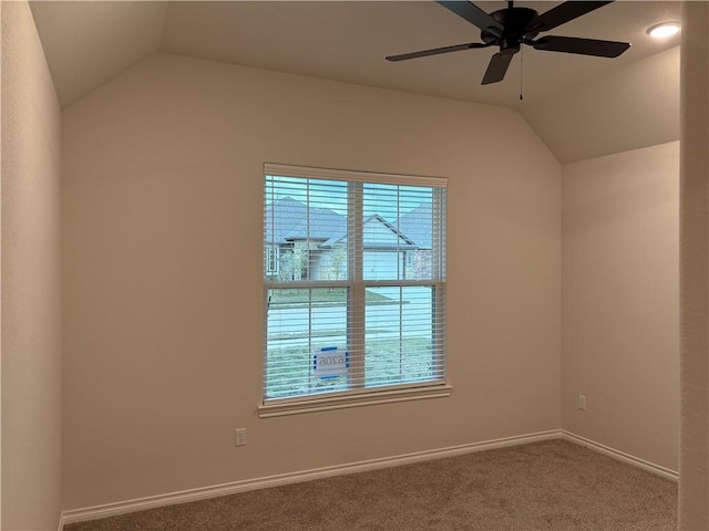 empty room with a wealth of natural light, ceiling fan, and vaulted ceiling