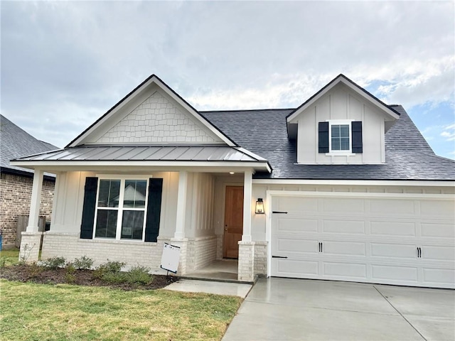 view of front facade featuring covered porch, a front yard, and a garage