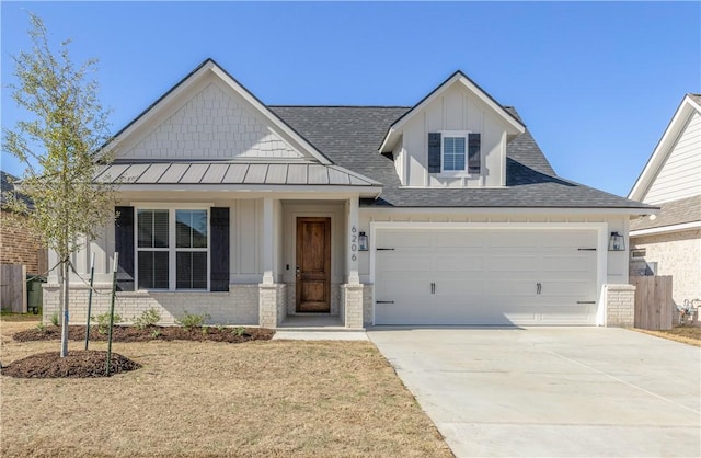 view of front of property with brick siding, board and batten siding, concrete driveway, metal roof, and a standing seam roof