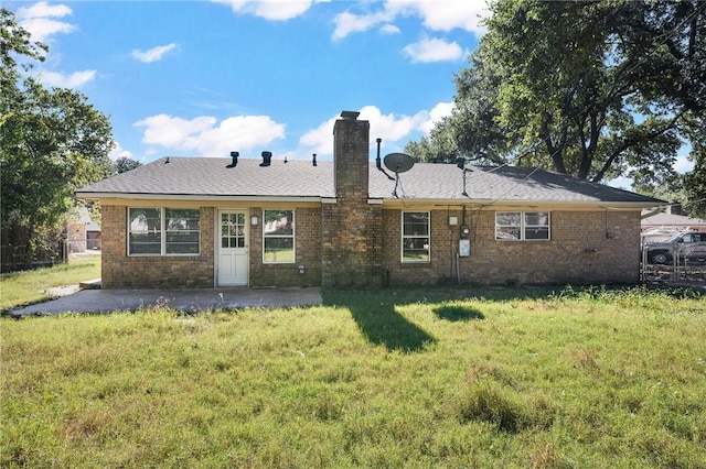 rear view of house with a lawn and a patio