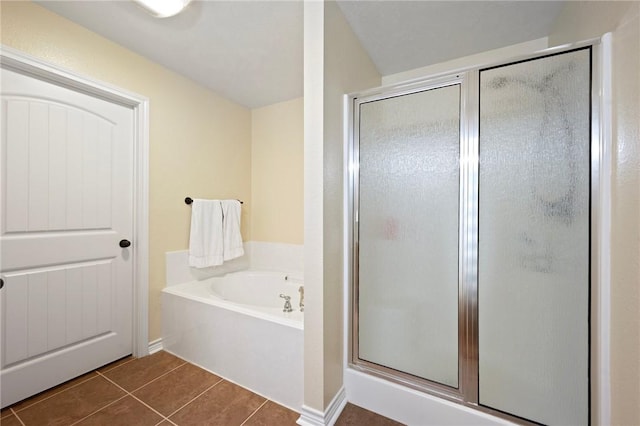 bathroom featuring a shower stall, a bath, and tile patterned flooring