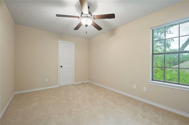 unfurnished room with light colored carpet, plenty of natural light, and baseboards