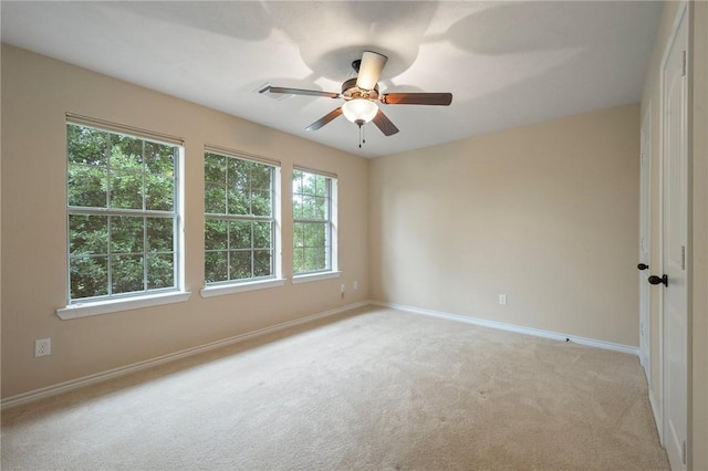 unfurnished room featuring light colored carpet, ceiling fan, and baseboards